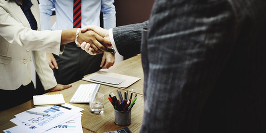 Business handshake across a desk