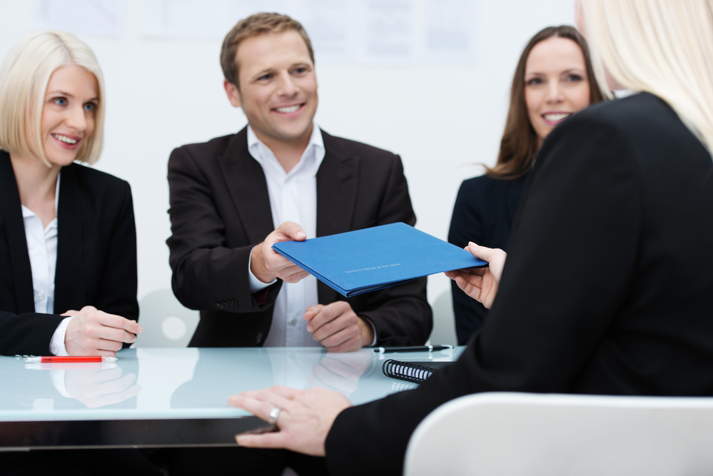 Handing over a blue folder in a meeting